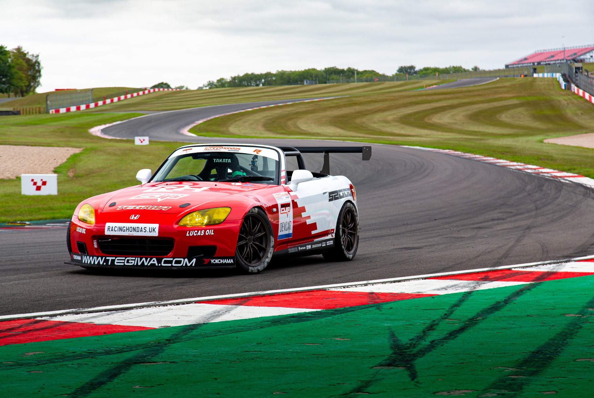 3/4 front view of a Honda S2000 racing car at a track