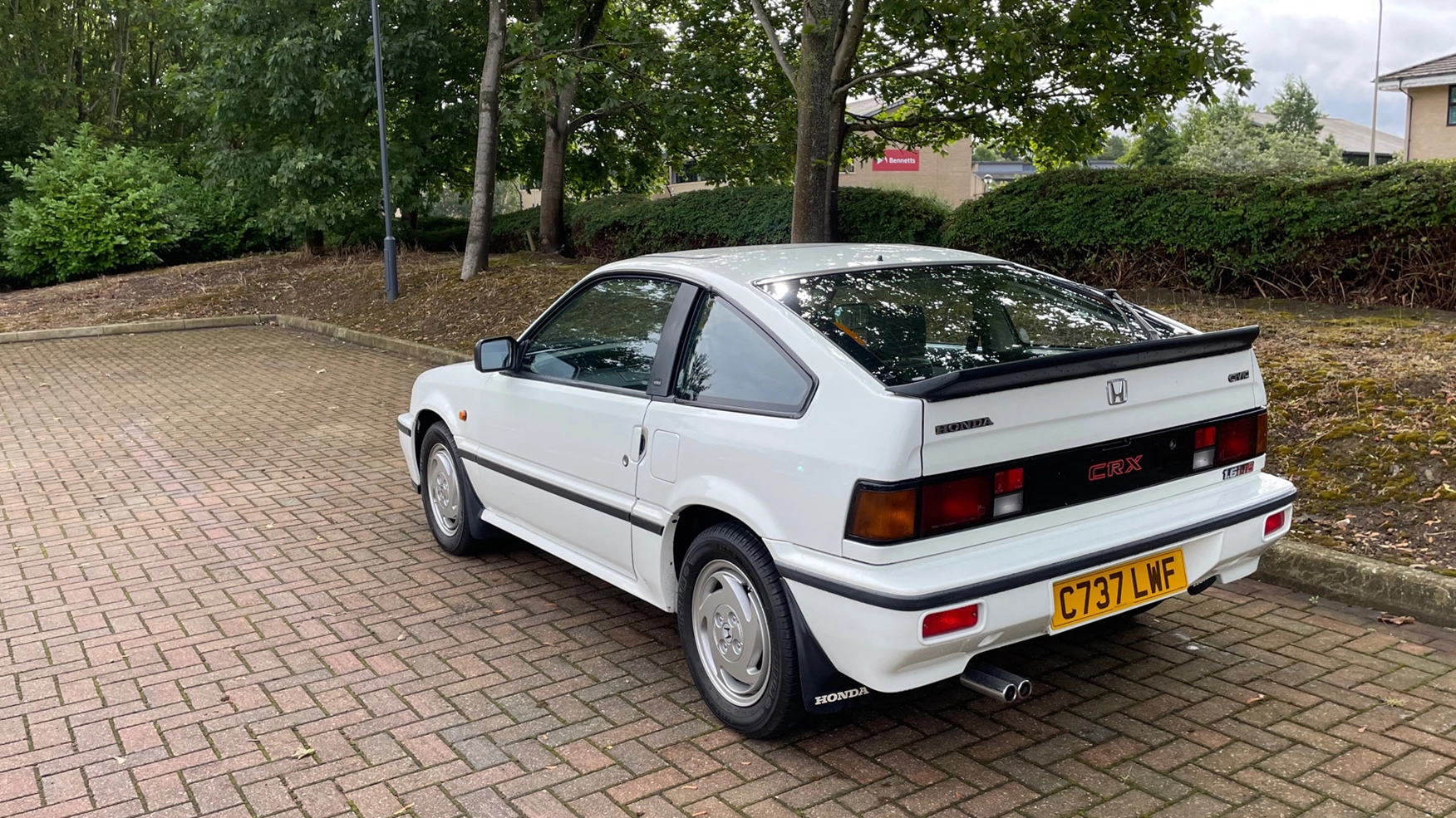 Three-quarter rear view of a 1985 white Honda CR-X