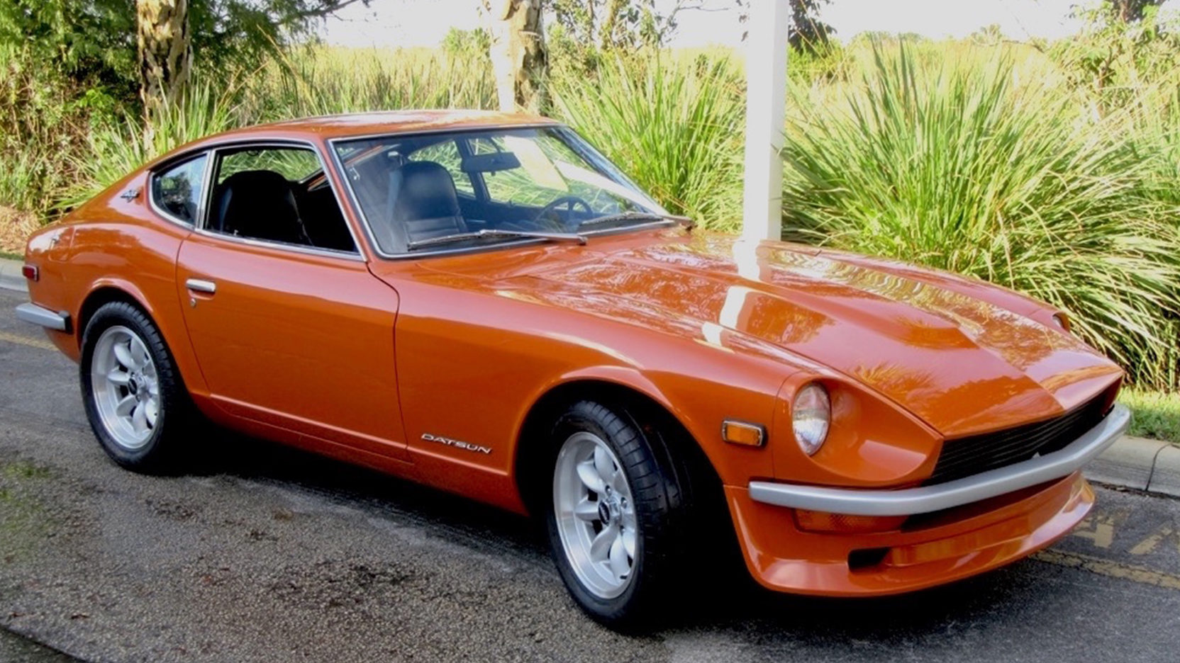 Red 1970 Datsun 240Z parked by side of road