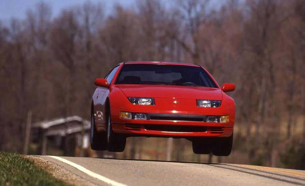 Red Nissan 300ZX Twin Turbo gaining air as it crests hill