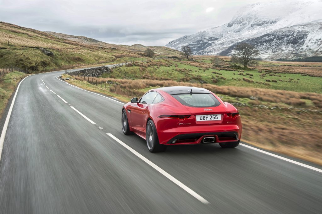 Jaguar four-cylinder F-Type rear press shot driving sports car supercars