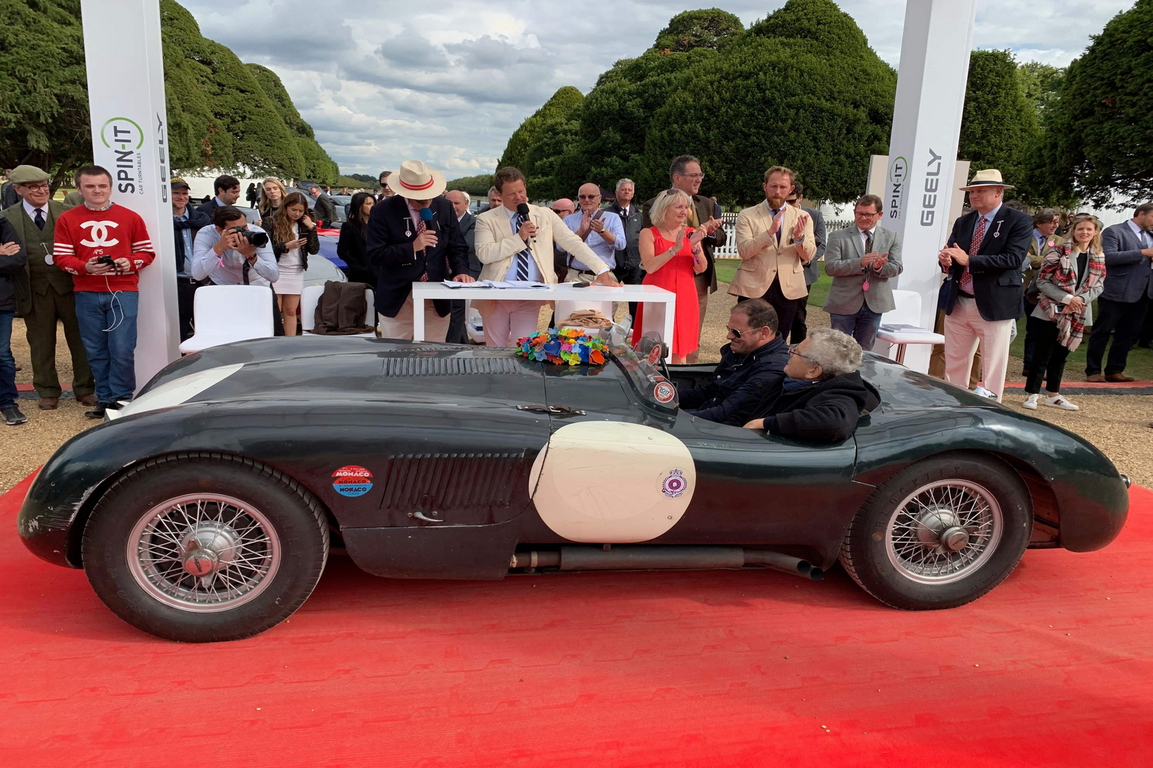 Jaguar C-Type surrounded by a crowd of people at the Concours Stage