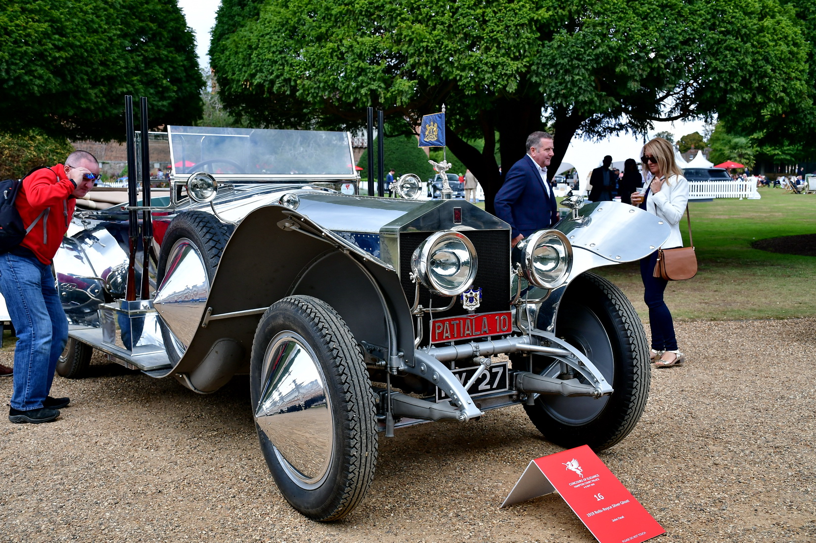 Rolls-Royce Silver Ghost from 1919 with polished aluminium body work adorned with a pair of Partiala 12-bore shotguns outside the driver's door