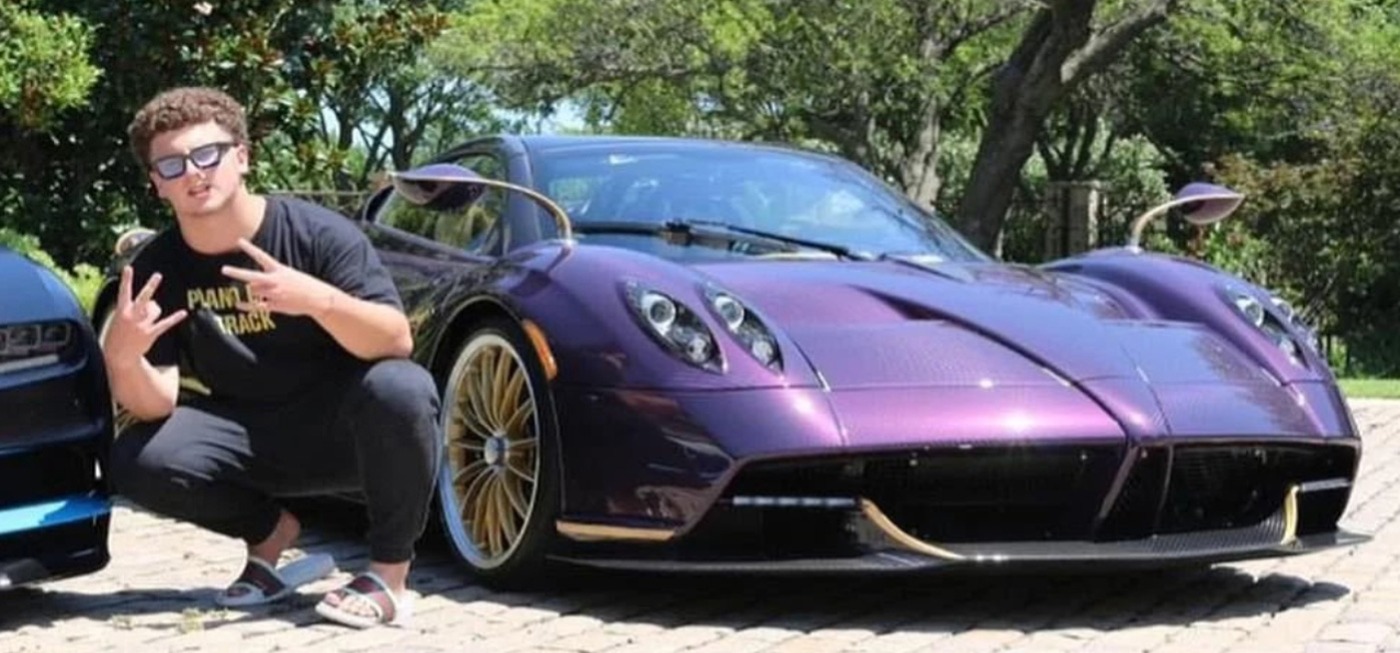 Boy posing with Purple Pagani Huayra Roadster