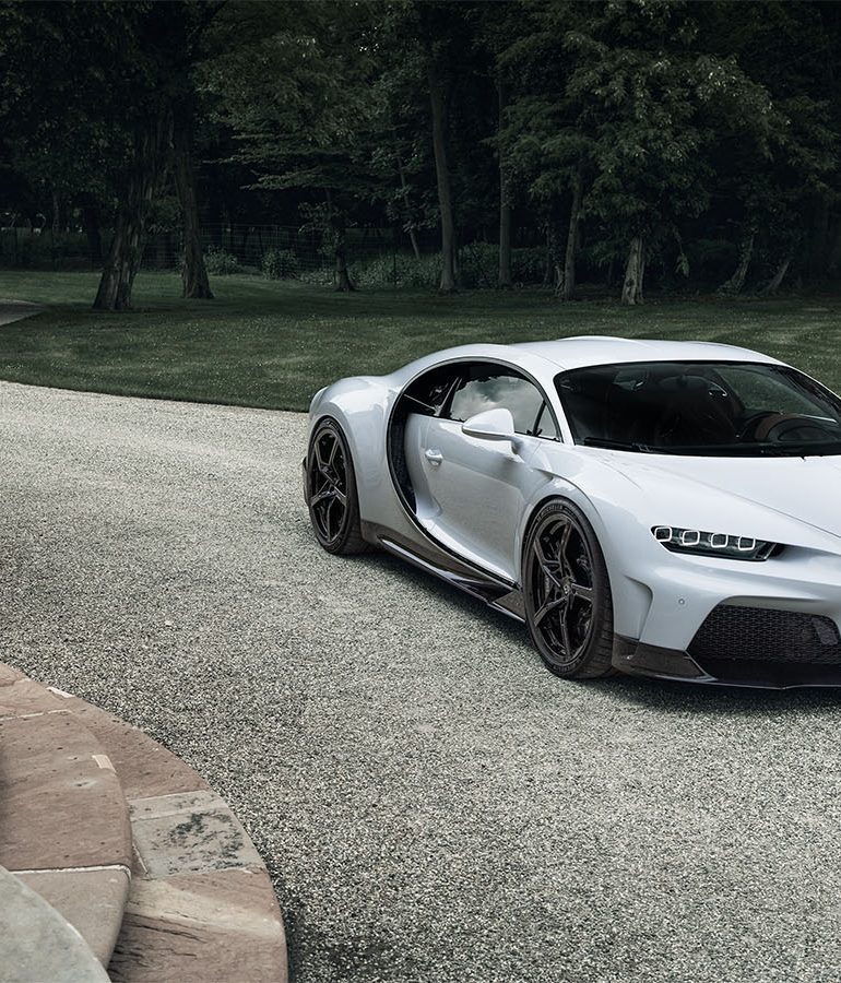 A view of a Bugatti Chiron parked at a driveway of a large staircase.