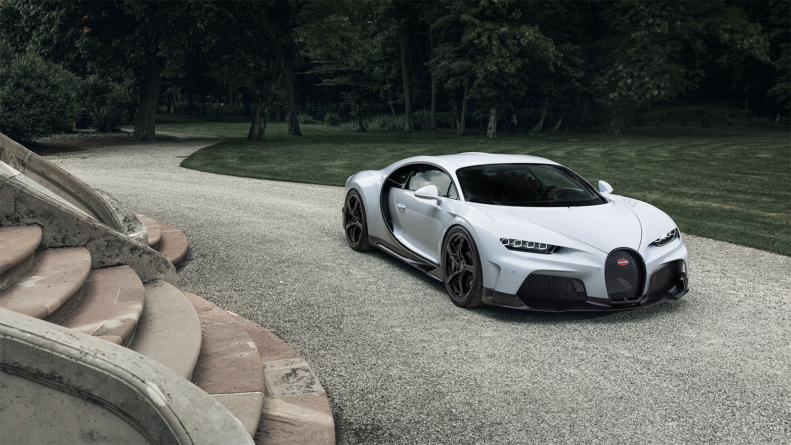 A view of a Bugatti Chiron parked at a driveway of a large staircase.