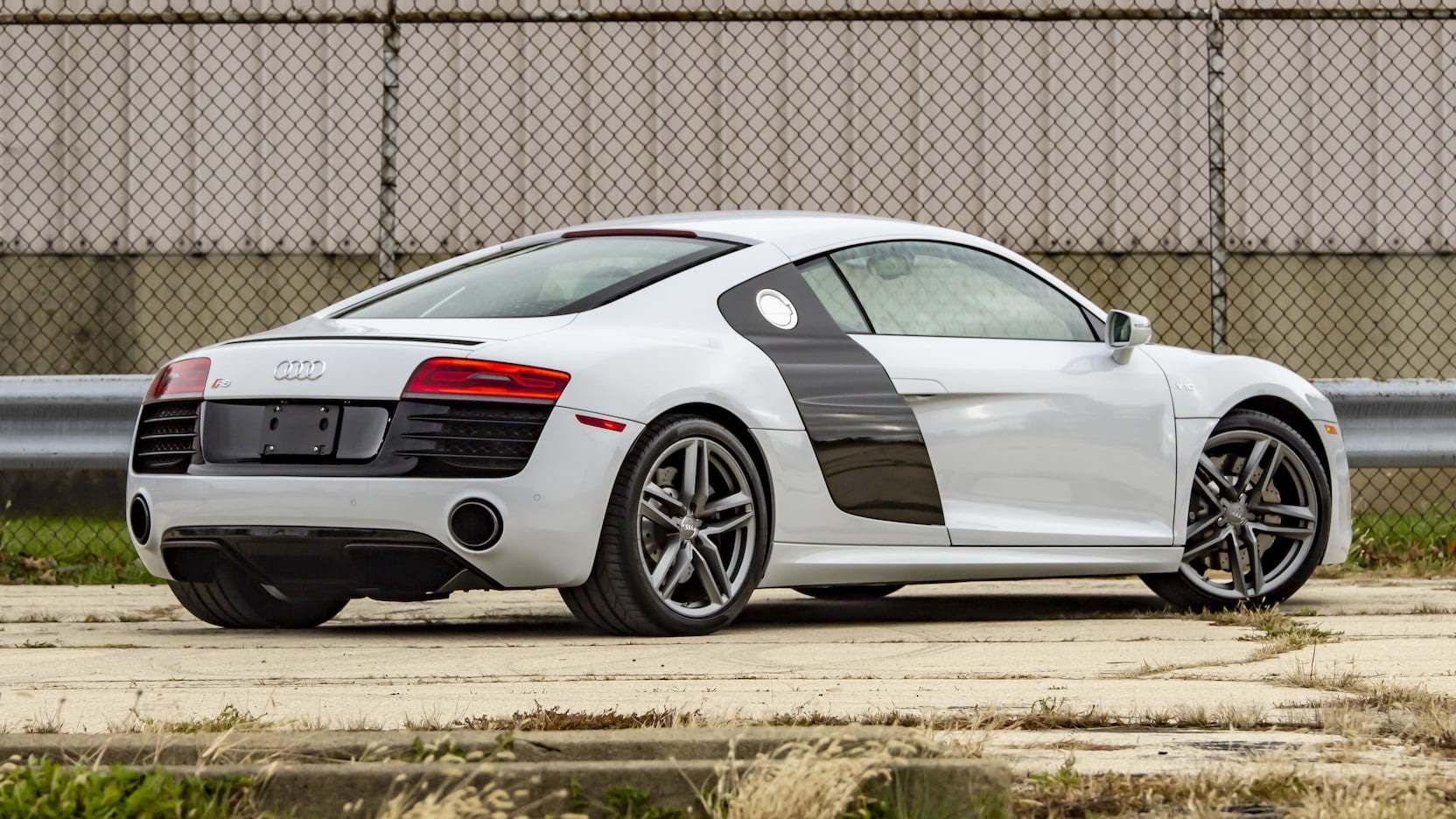 White Audi R8 parked outside near chain-link fence