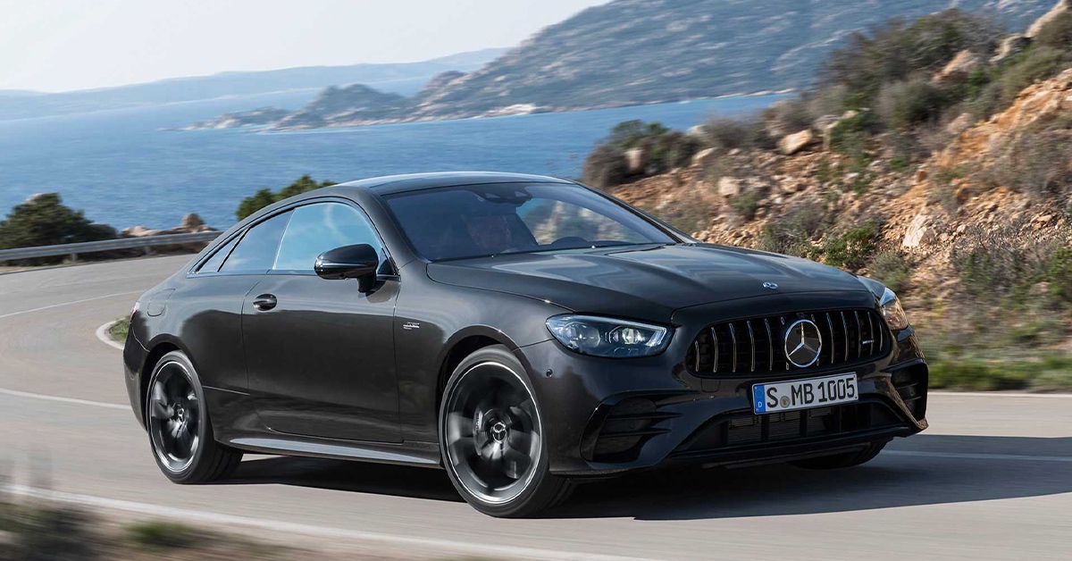 2022 black Mercedes AMG E53 on a curvy road by the ocean