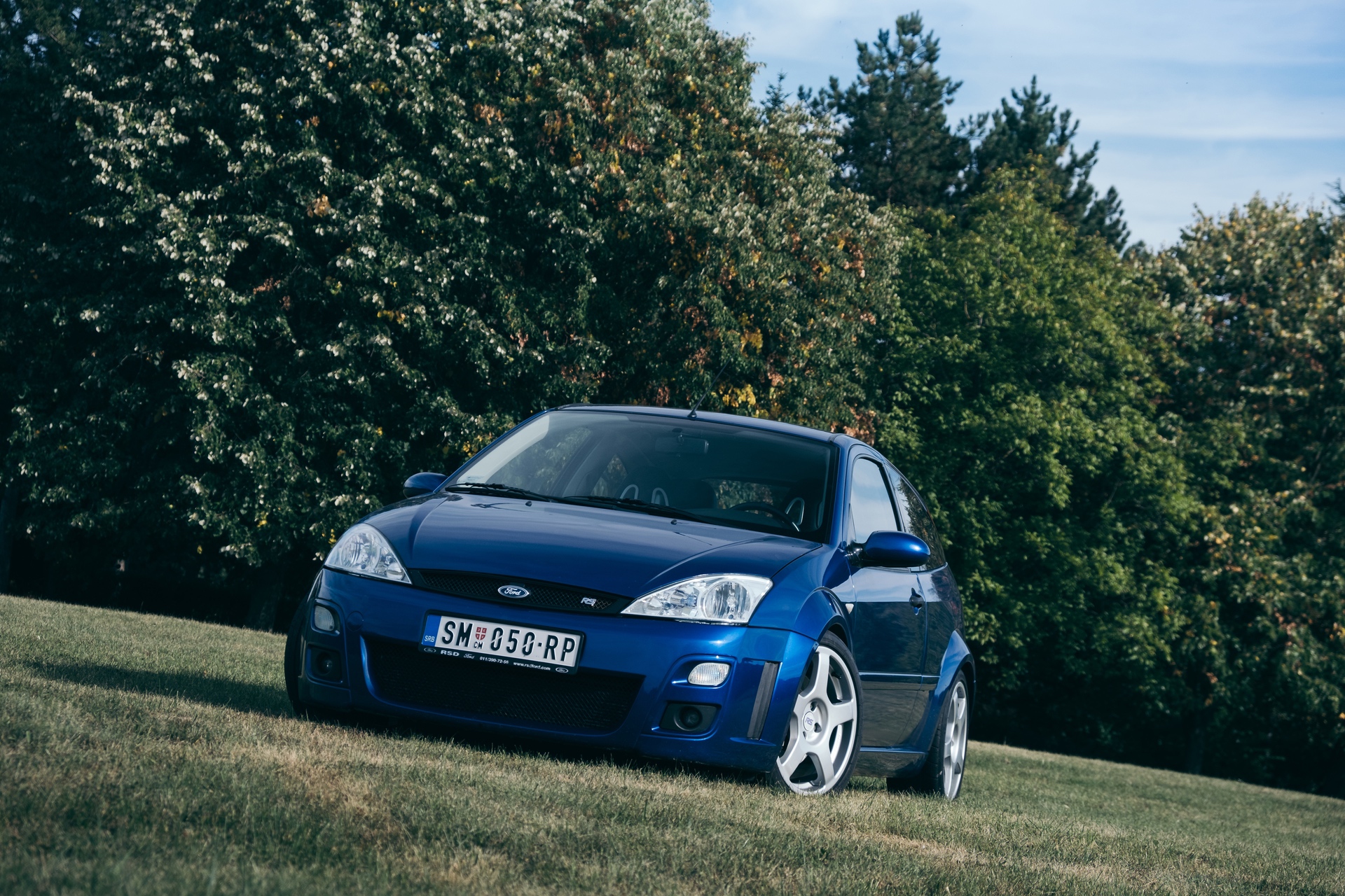 Front view of blue Ford Focus RS parked in grassy field