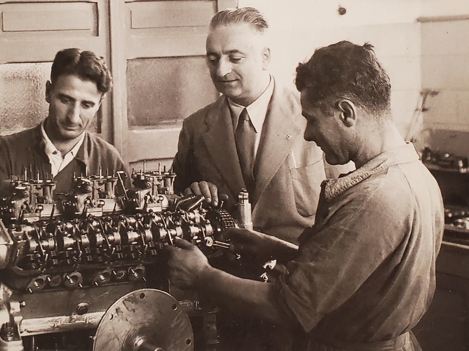 Enzo Ferrari supervising V12 engine assembly in the 1950s