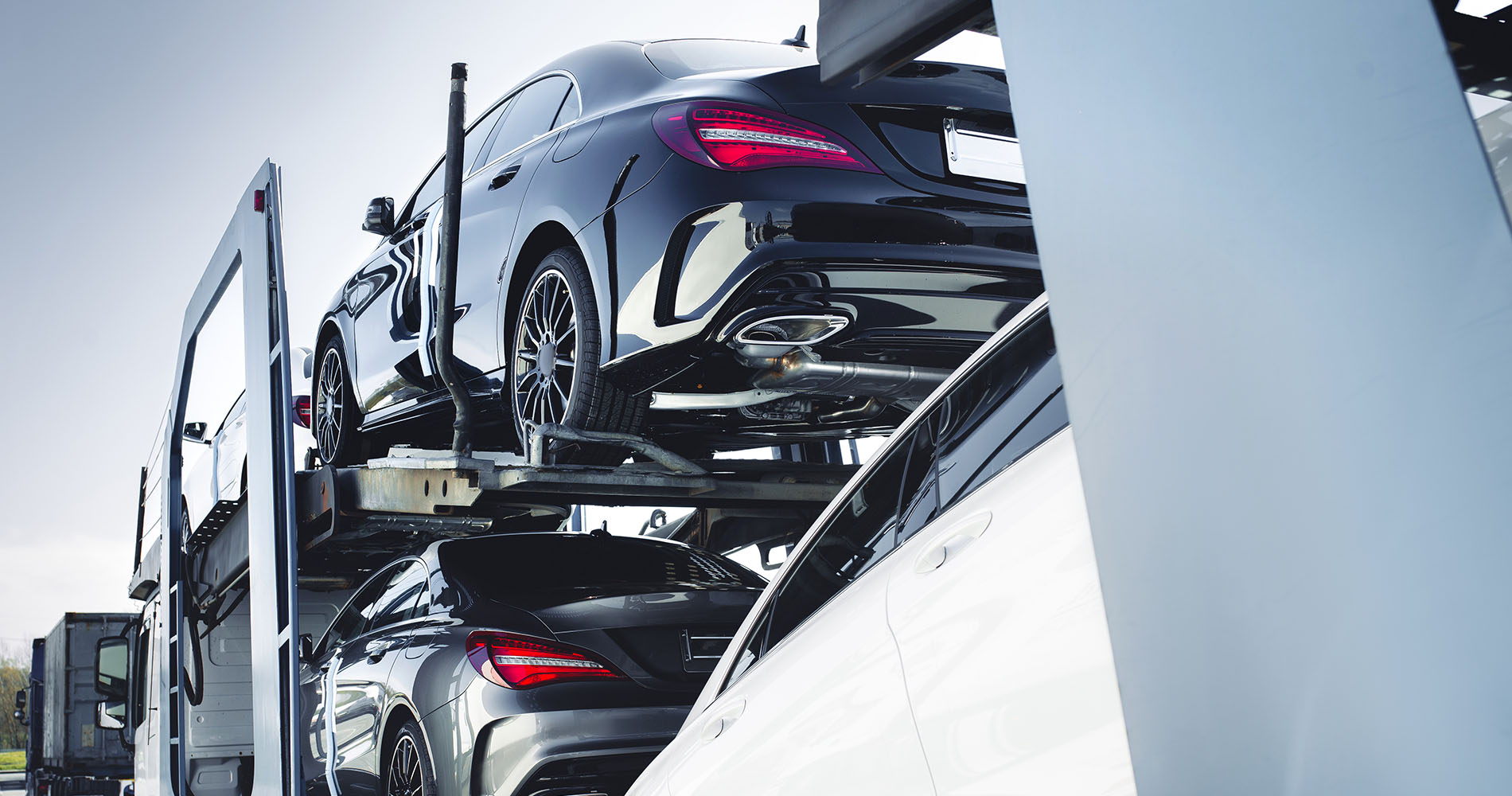 Mercedes Benz vehicles being transported on a car carrier truck.