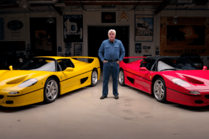 Jay Leno standing in front of yellow and red Ferrari F50
