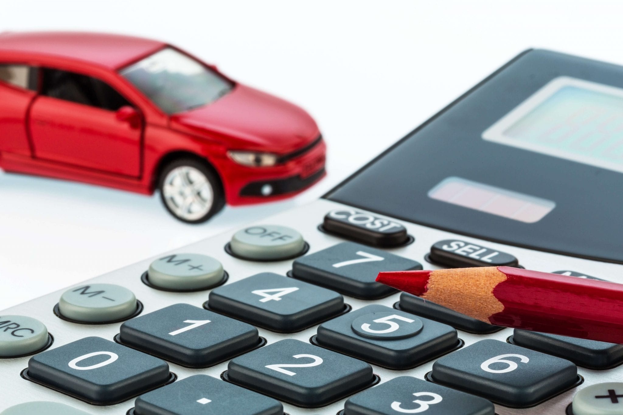 Close up of calculator with car in the background