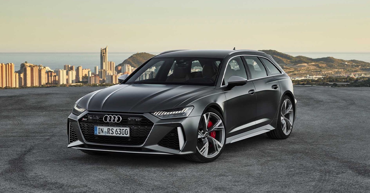 Black Audi RS6 Avant with coastal city background