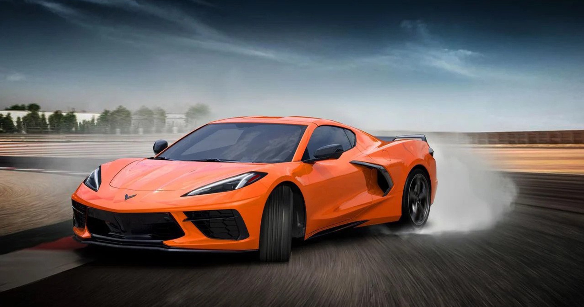 Orange C8 Corvette burning tire on a racetrack