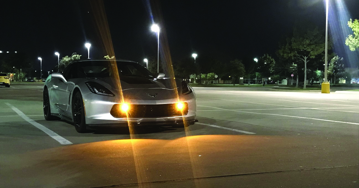 C7 Corvette in parking lot at night with yellow fog lights