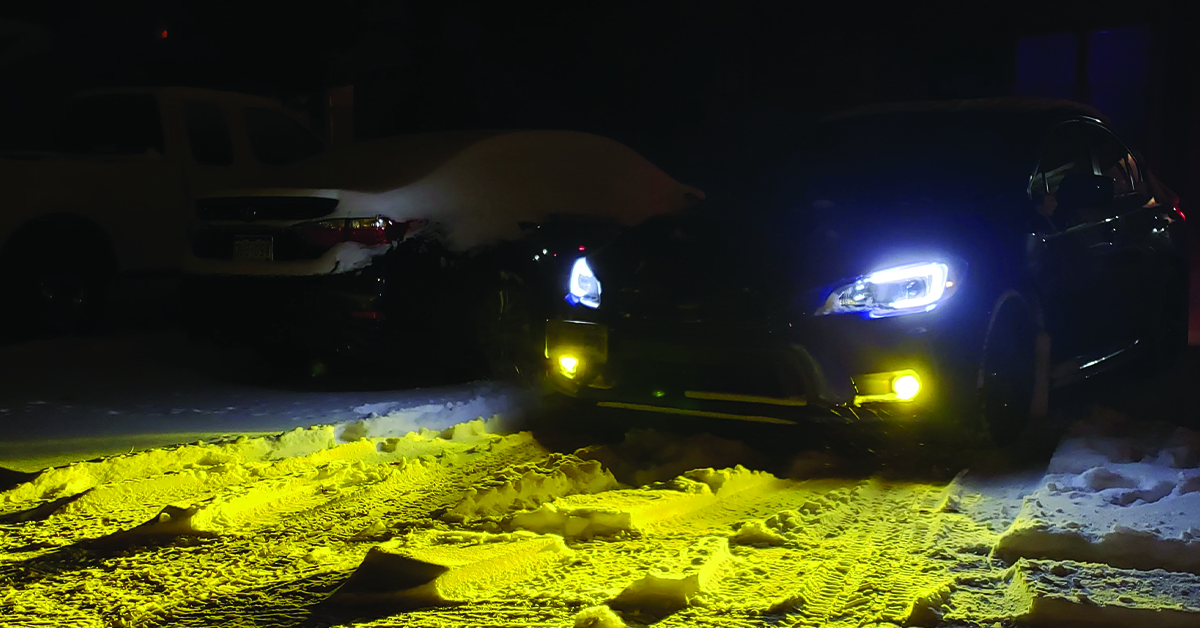 Subaru WRX with yellow fog lights in snow