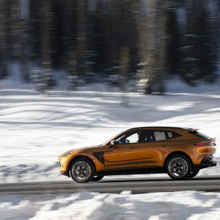 2021 Aston Martin DBX driving through snowy scenery