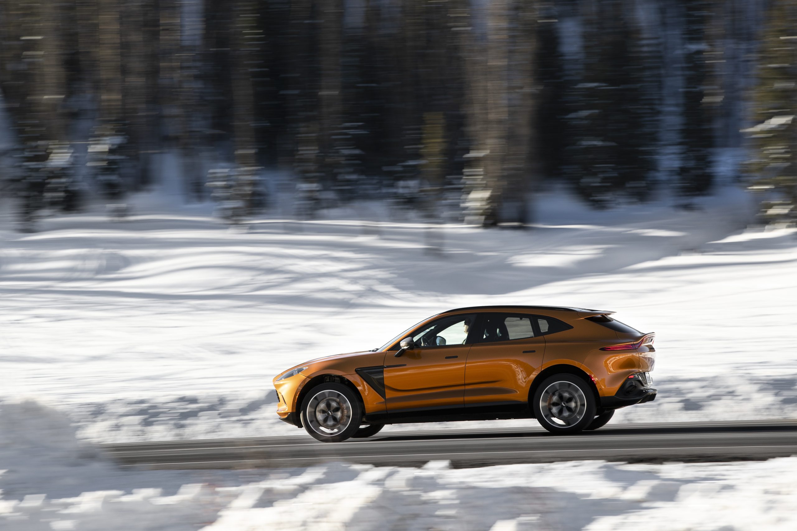 2021 Aston Martin DBX driving through snowy scenery