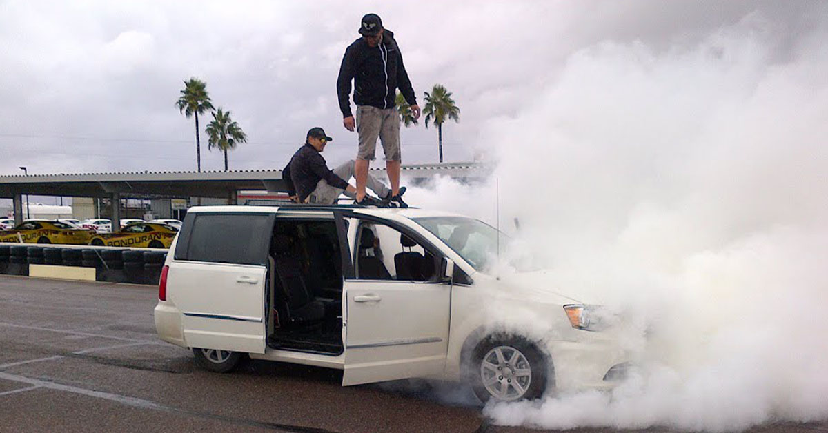 White Chrysler Town and Country mini van doing a burnout