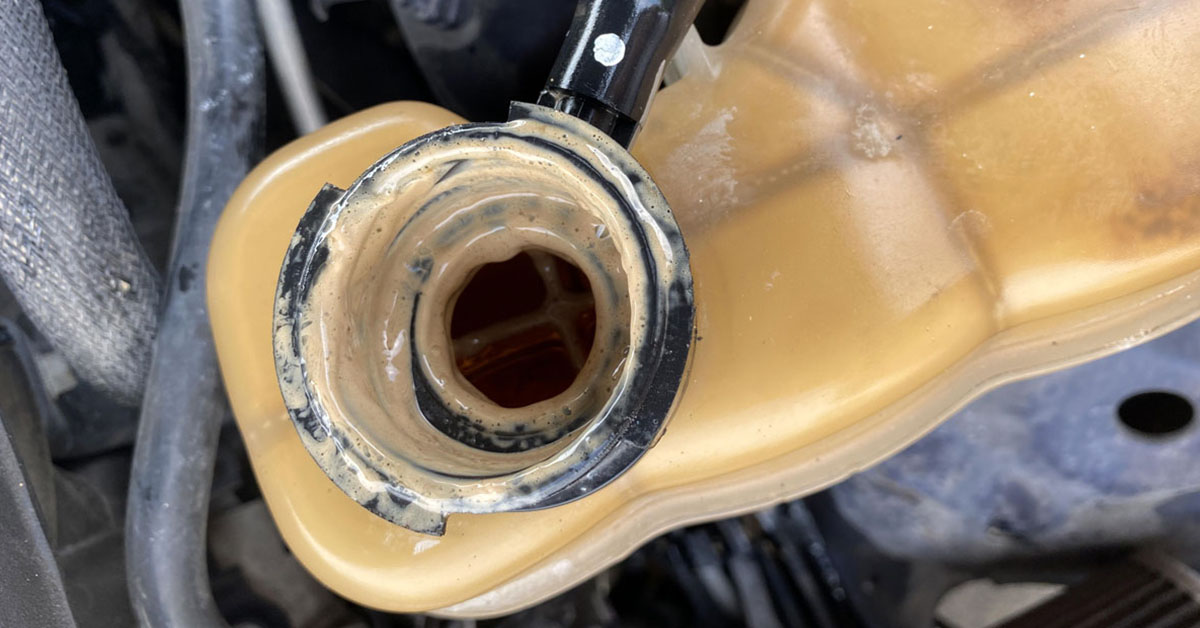 Coolant reservoir covered with engine oil