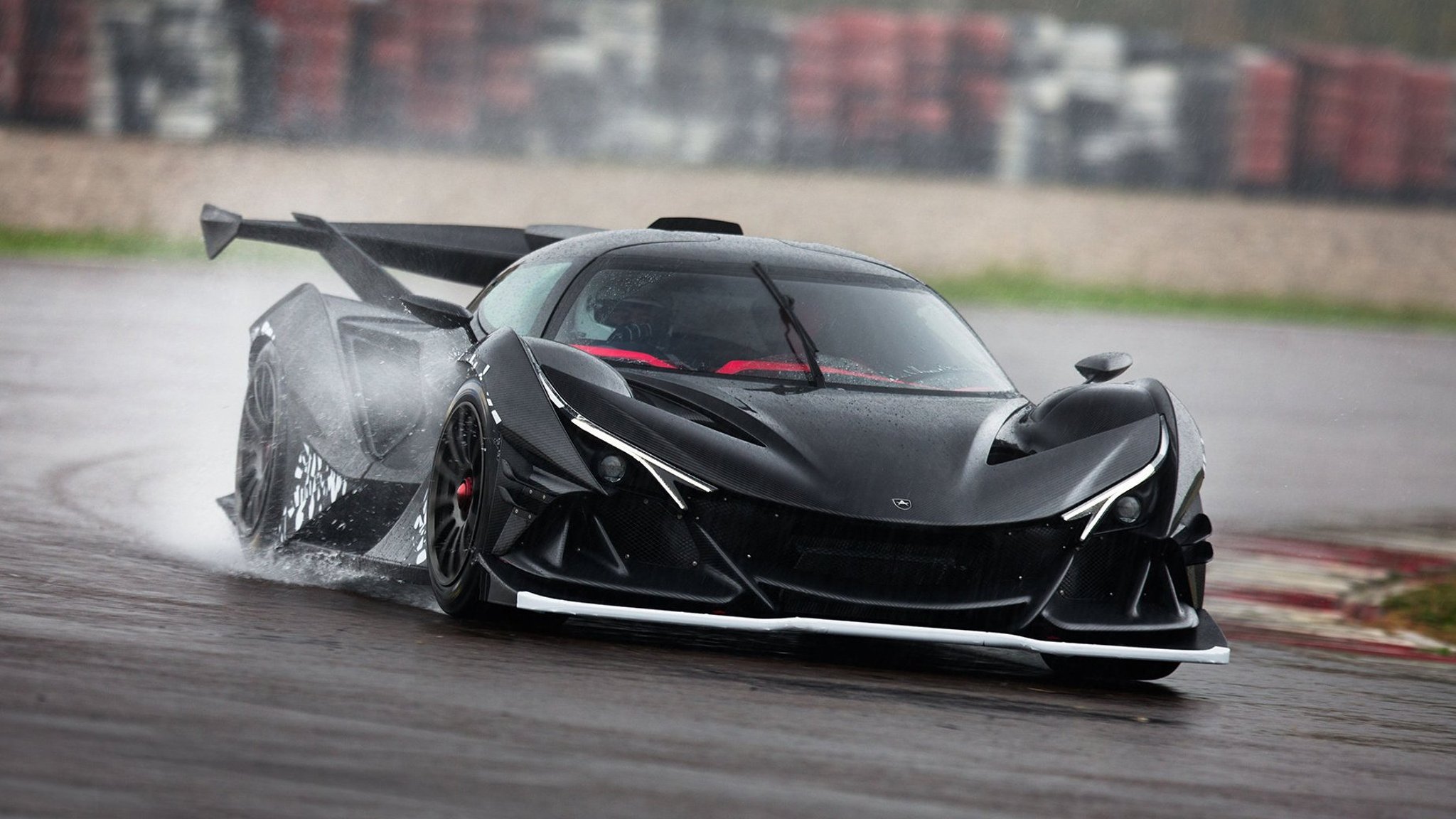 Image showing a black Apollo Intensa Emozione driving on a wet race track.