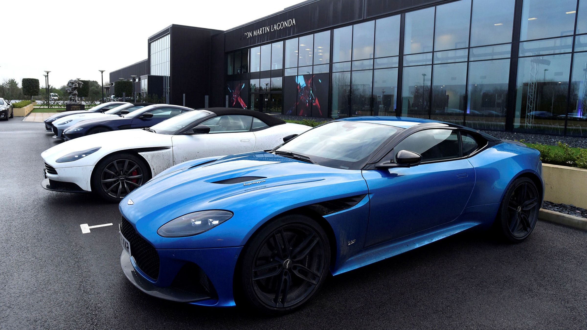 A row of Aston Martin cars outside a dealership