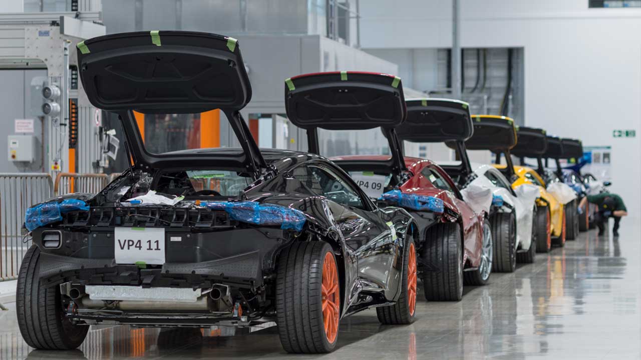 Rear-angled Image showing a line of Lotus Cars at the factory's assembly line.