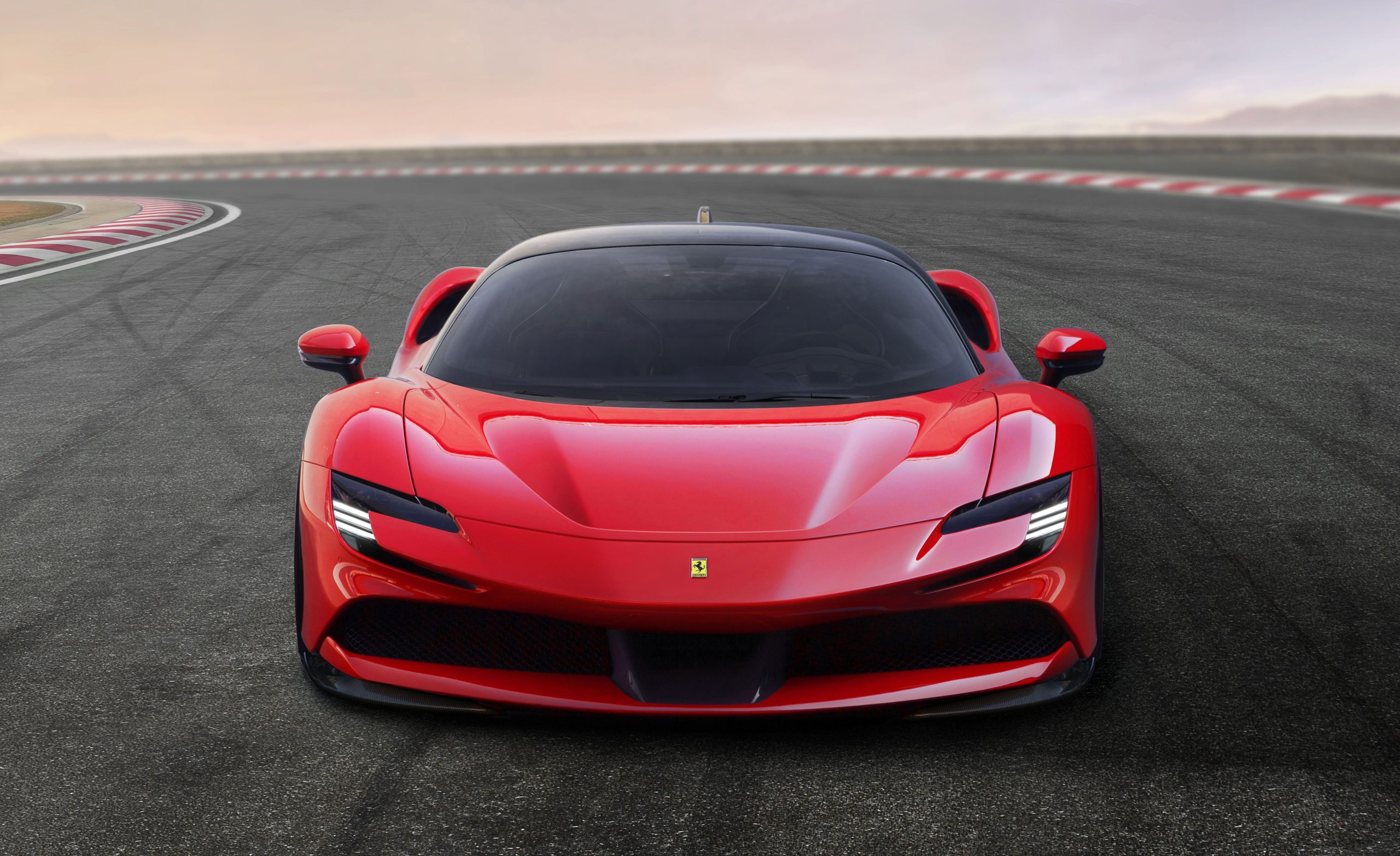 Full frontal image of a red Ferrari SF90 Stradale on a race circuit.