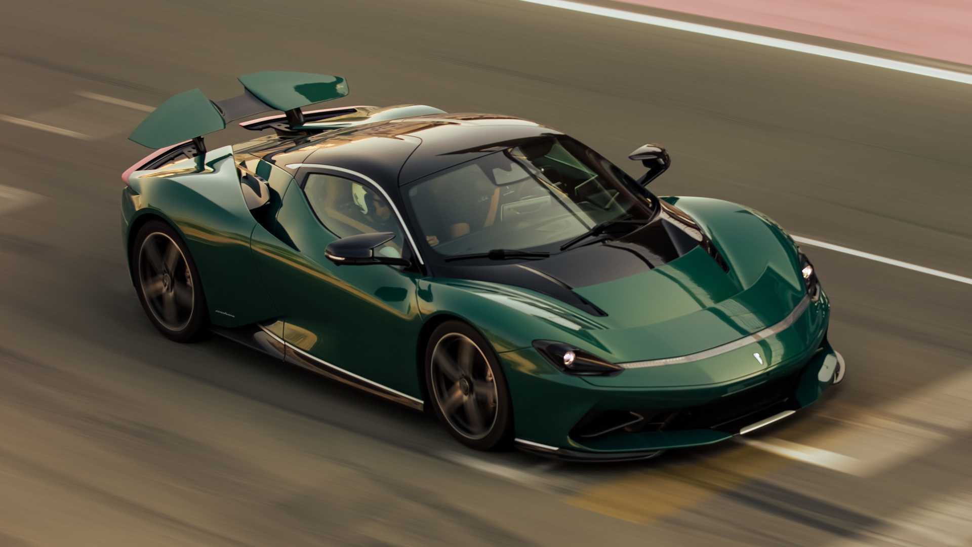 A rolling shot of a dark green Pininfarina Battista hypercar on a race circuit.