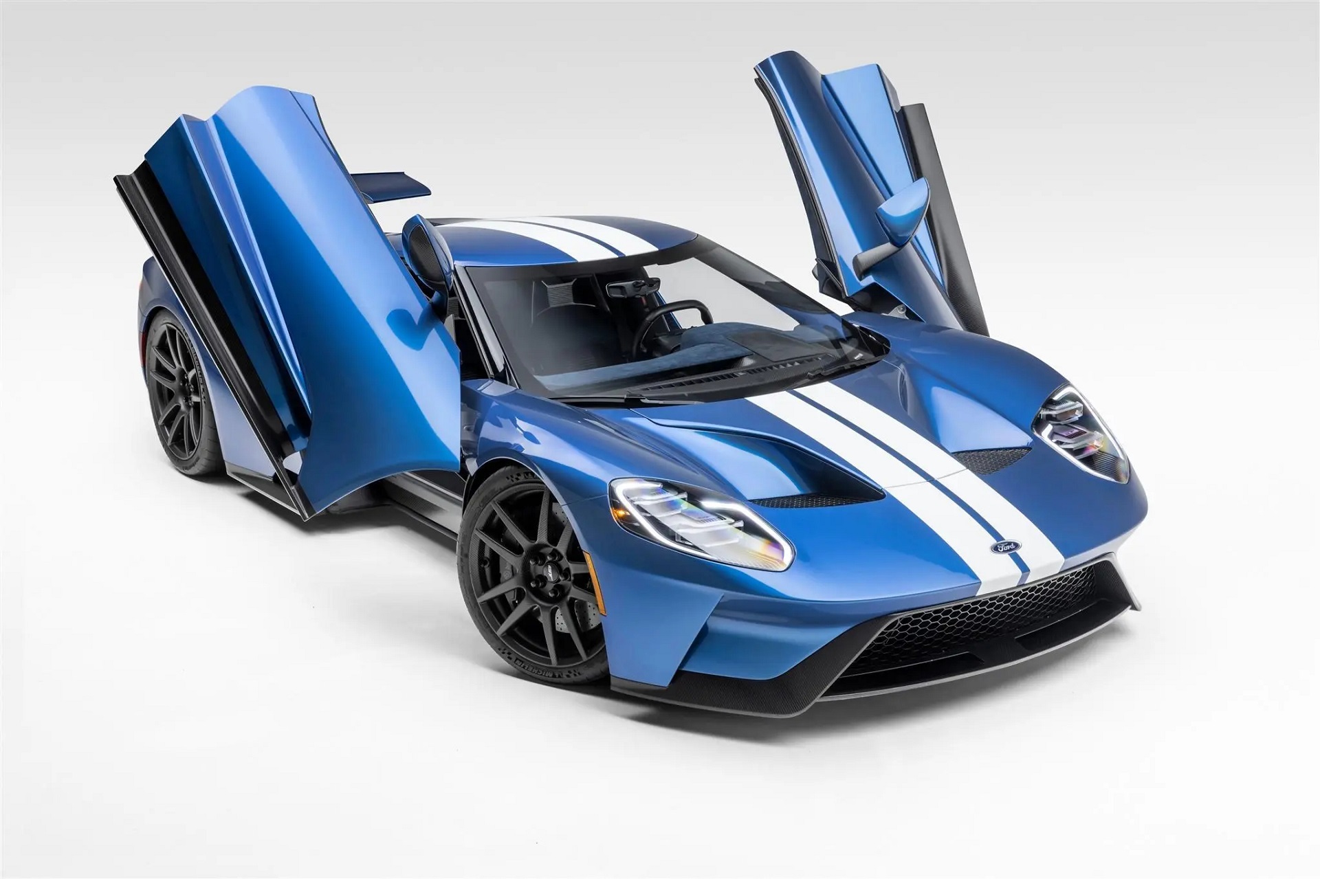 Front-angled view of a 2019 Ford GT with its butterfly doors open.