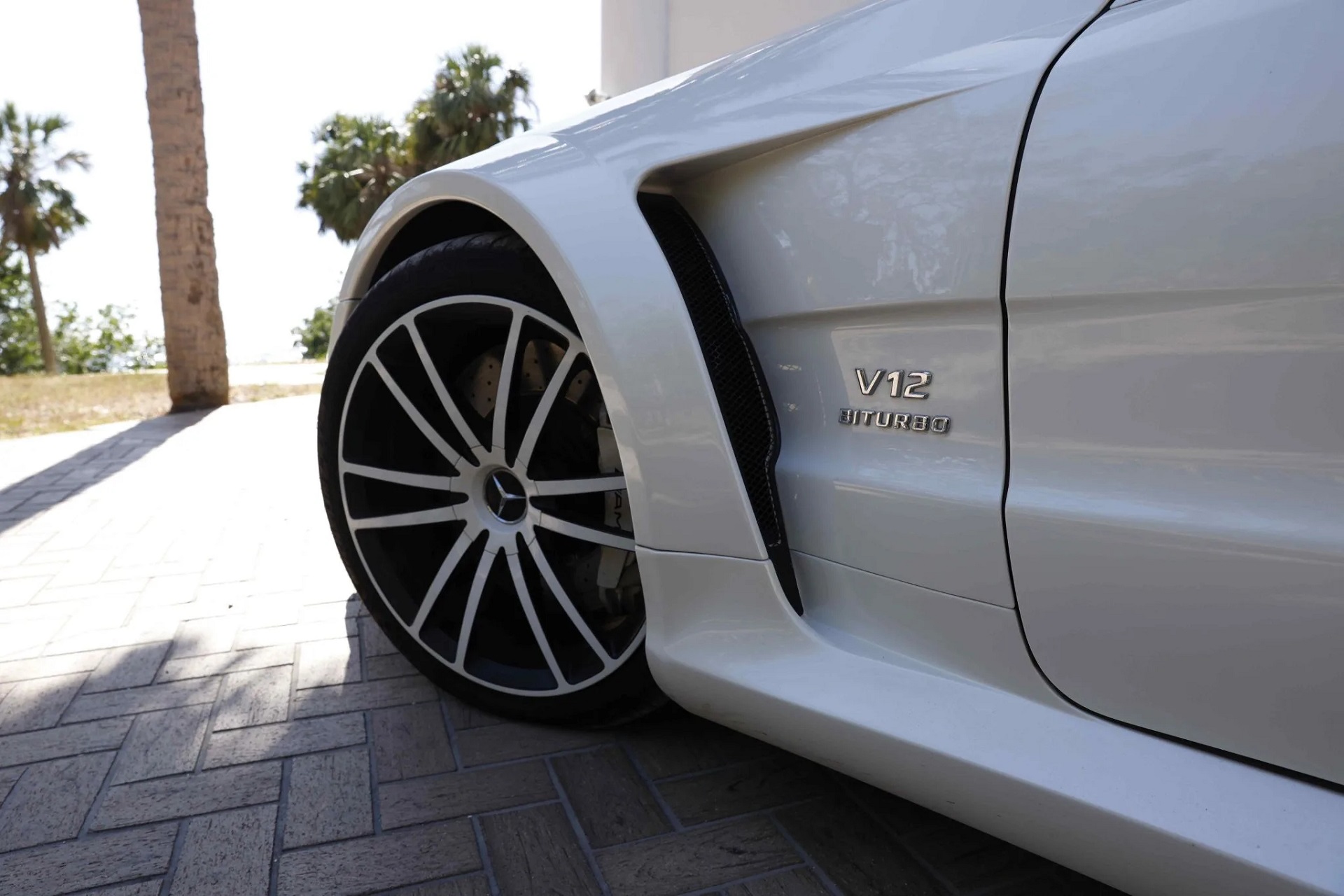 image showing the enlarged front fender and wheel of a white 2009 mercedes benz sl65 amg black series