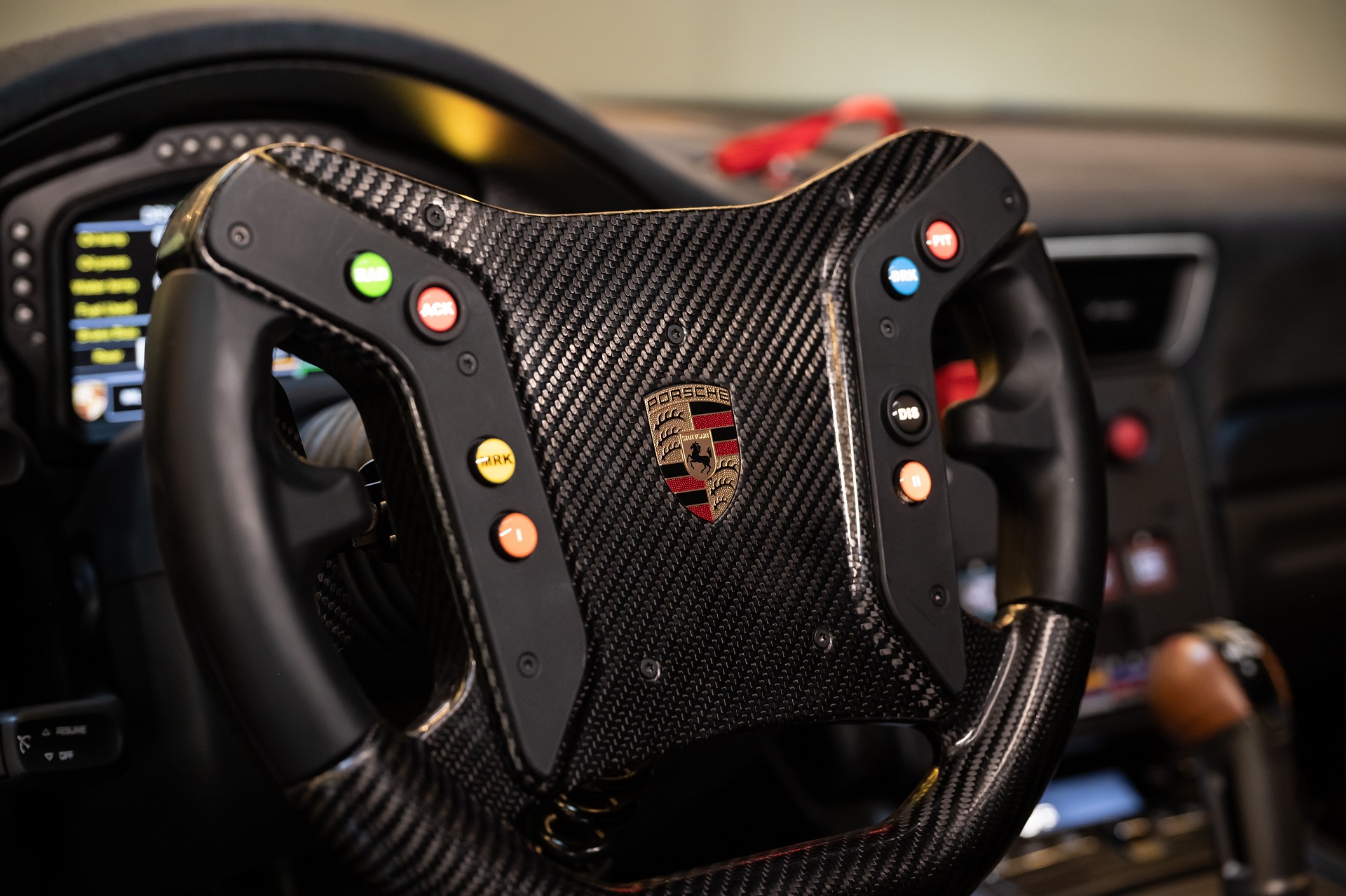 A close-up image of the racing steering wheel of a Gulf-liveried 2019 Porsche 935
