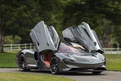 Front-angled view of a 2020 Grey McLaren Speedtail with butterfly doors open.