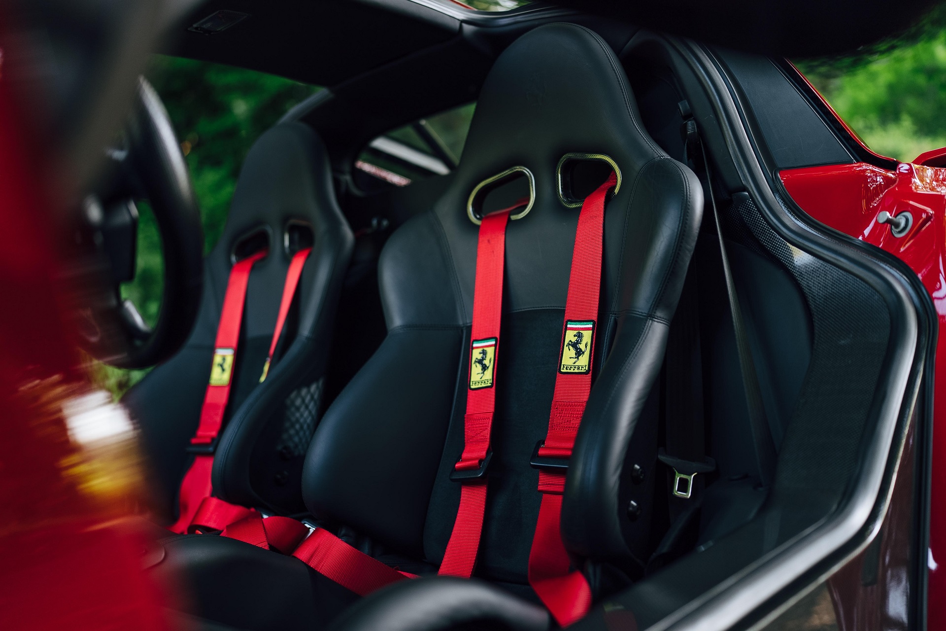 Another interior look of the red 2003 Ferrari Enzo showing the black seats in the cabin.