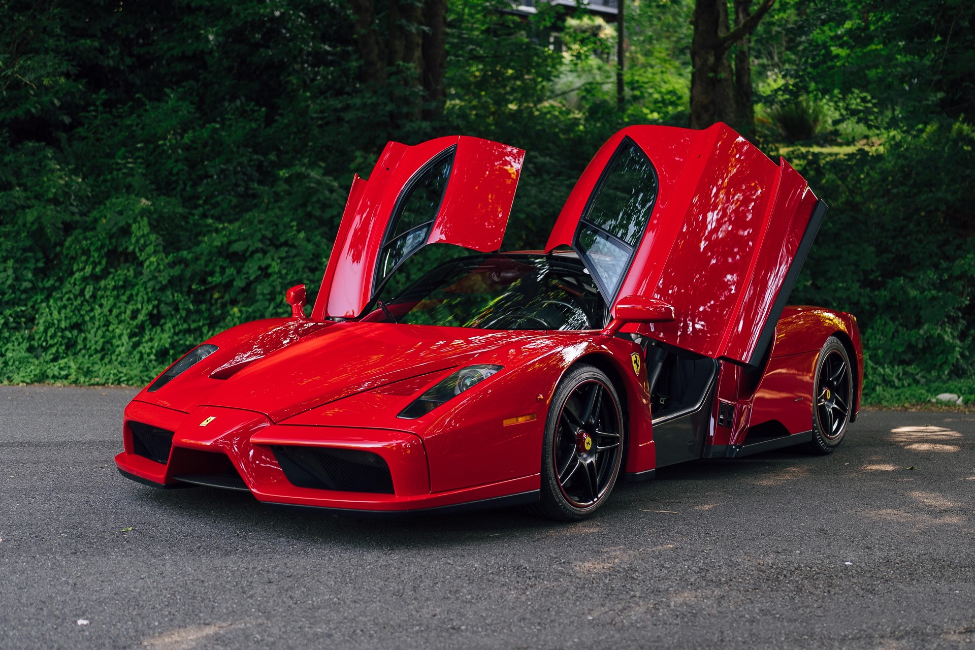 front-angled view of the red 2003 Ferrari Enzo with the doors open.