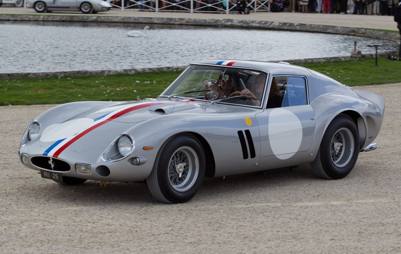 Front-angled view of a silver Ferrari 250 GTO with a red, white and blue stripe running from the hood to the boot.