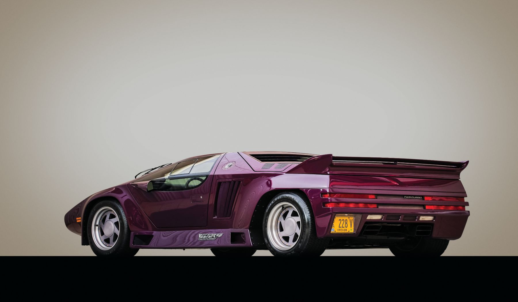 Image showing the rear-angled profile of a purple Vector W8 supercar.