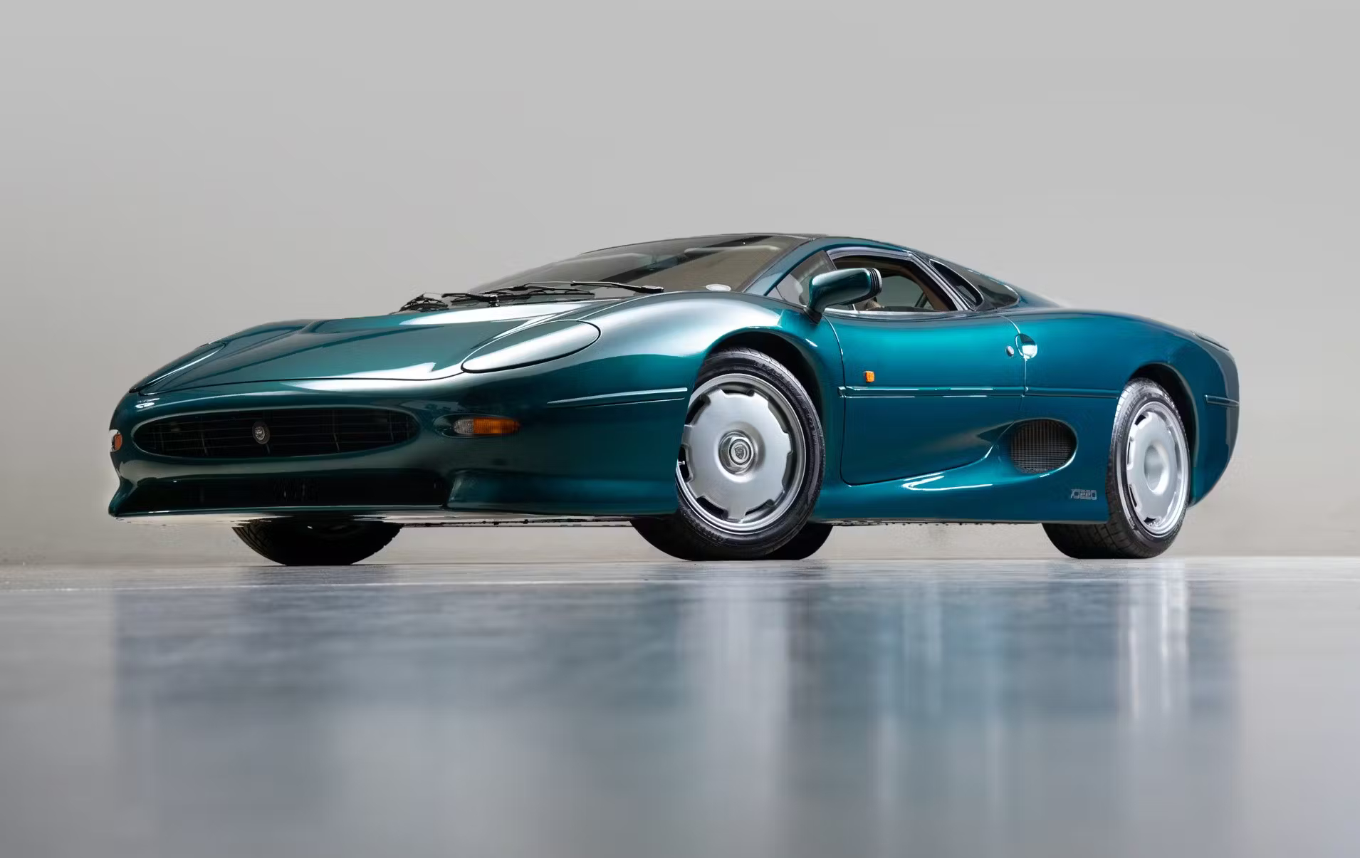 Image showing the low-slung side profile of a green Jaguar XJ220.