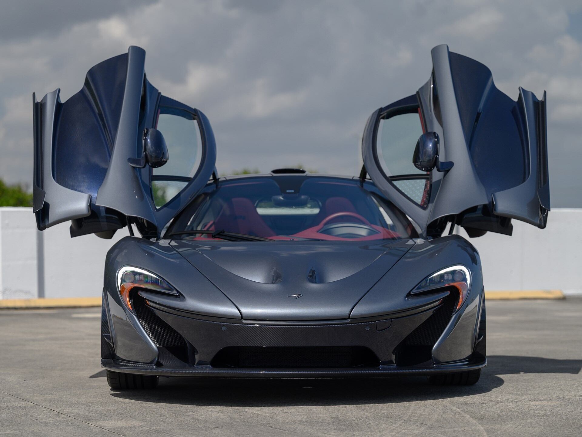 Front view of a grey 2015 McLaren P1 with butterfly doors open