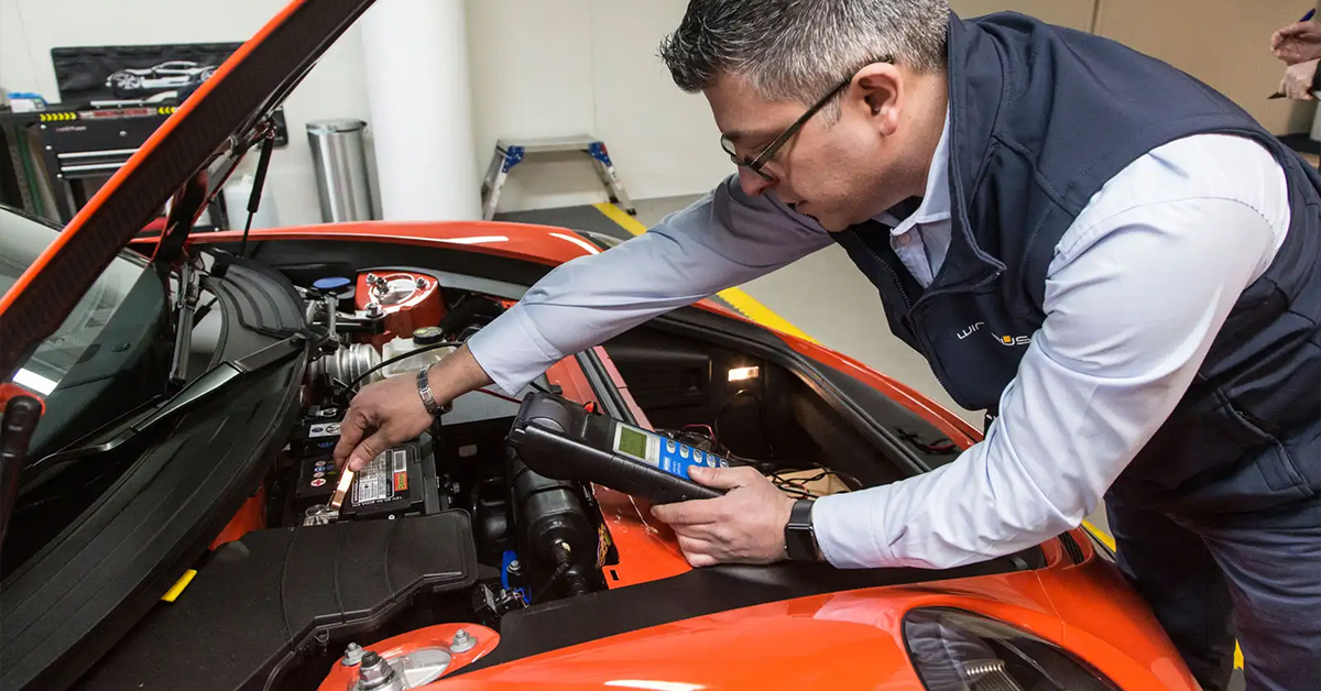 car technician inspecting a Porsche