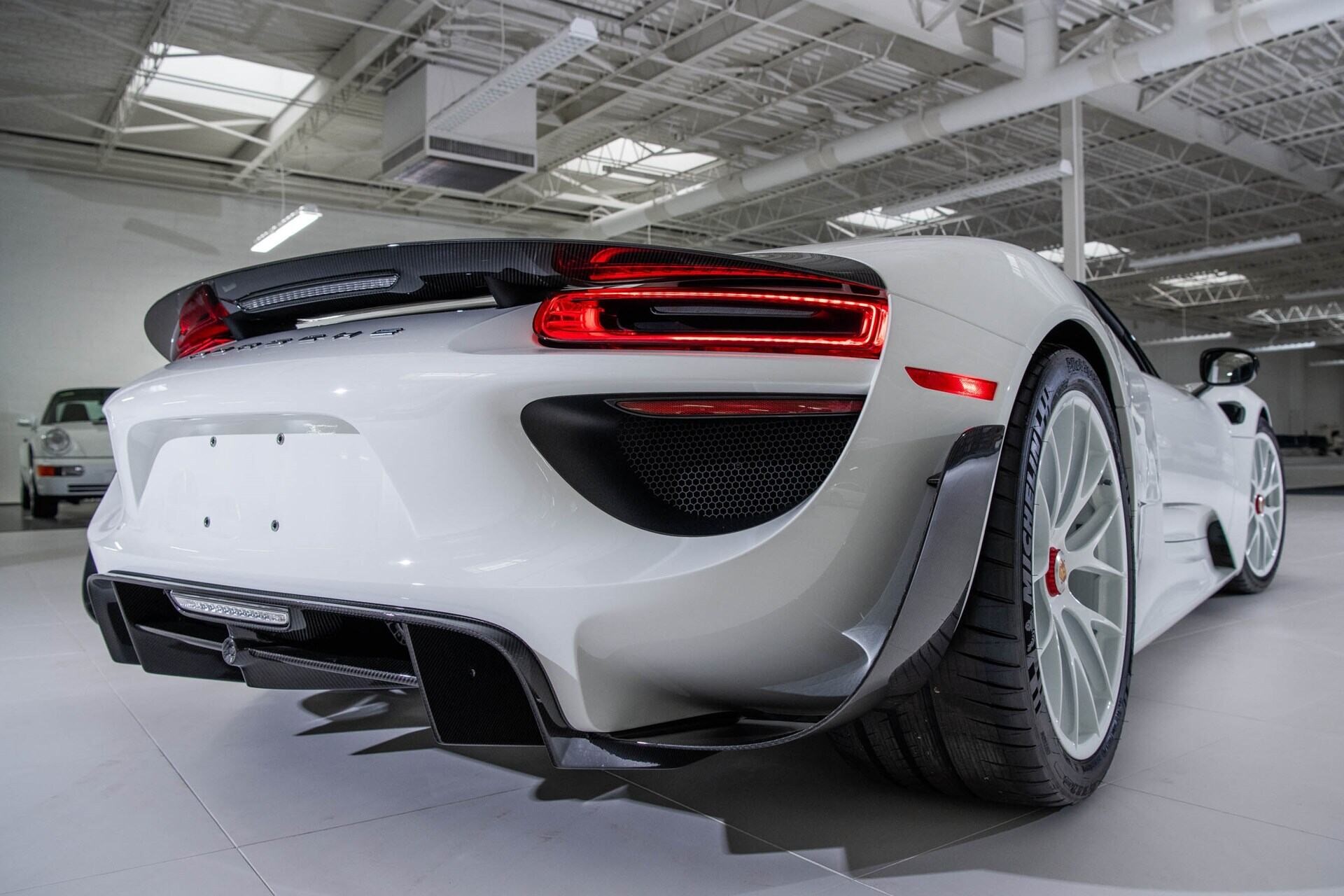 Rear-angled view of a white 2015 Porsche 918 Spyder