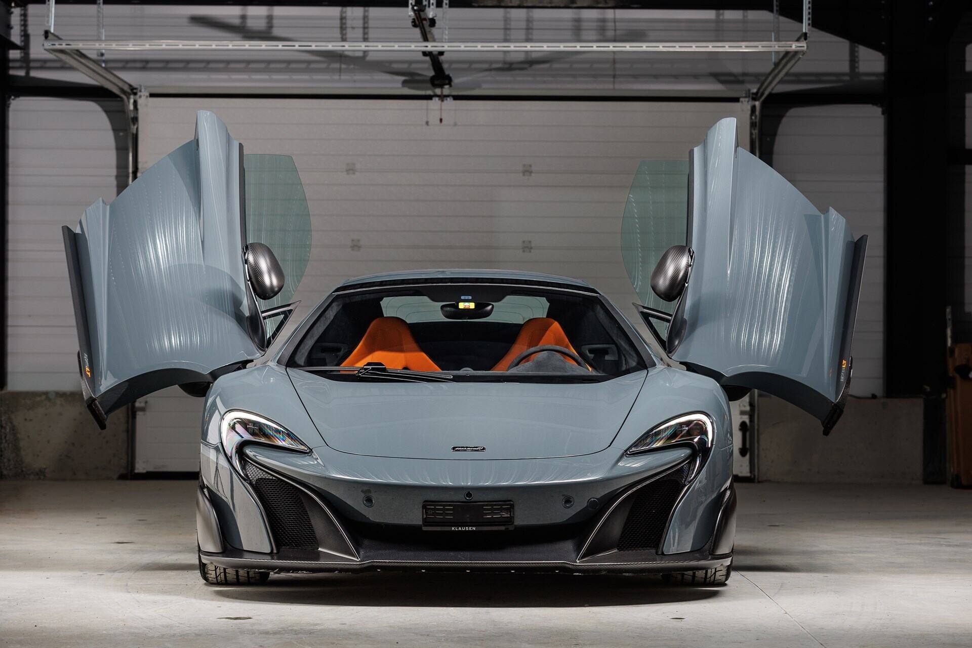 Frontal view of a 2017 Chicane Grey McLaren 675LT with butterfly doors open
