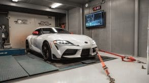 Three-quarter front view of a 2020 white Toyota Supra being tested on a dyno
