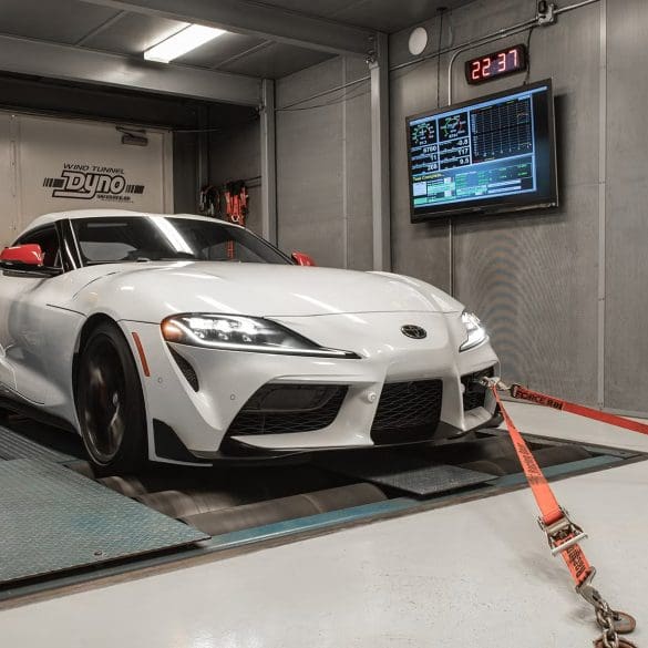 Three-quarter front view of a 2020 white Toyota Supra being tested on a dyno
